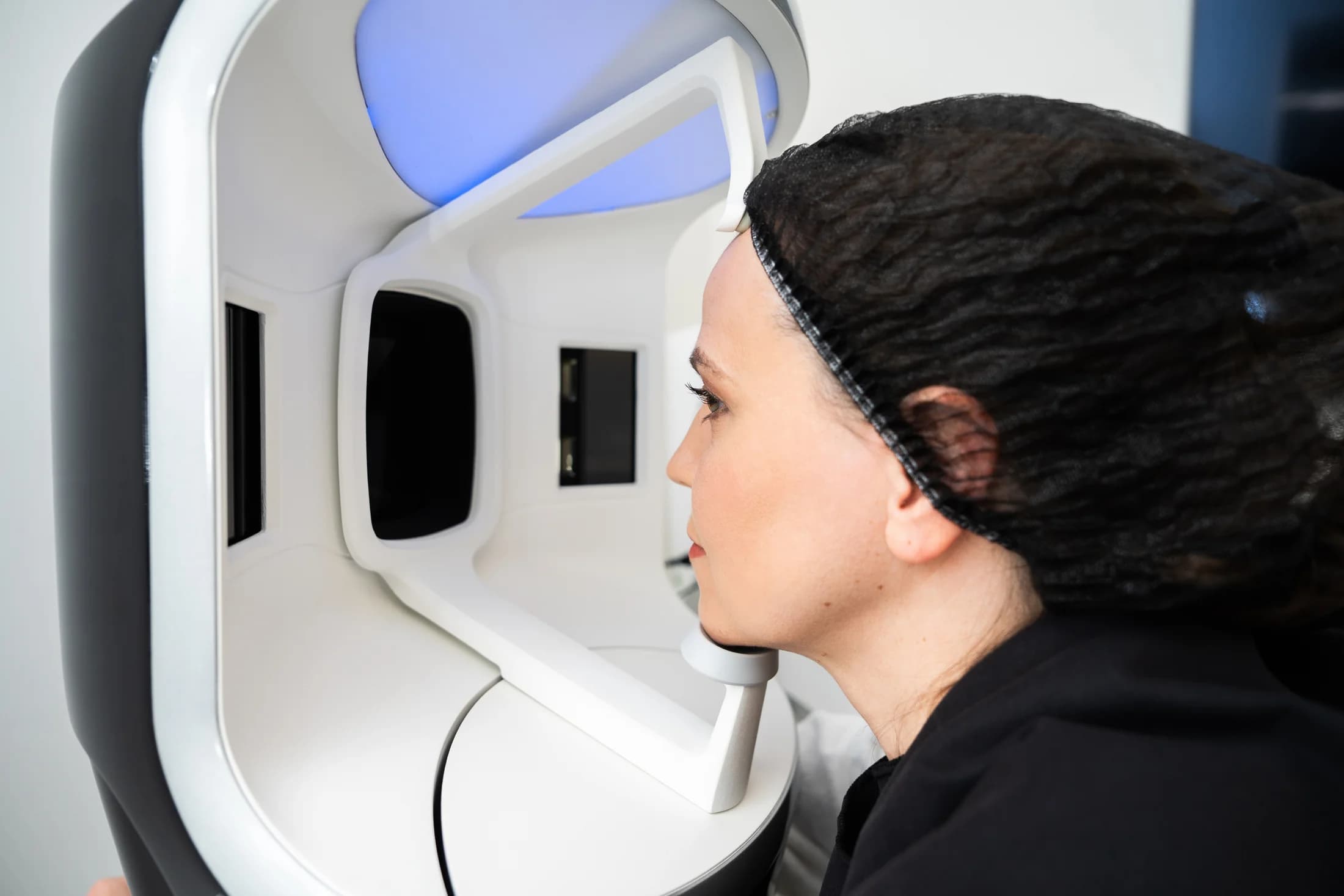 Client positioned in a facial skin analysis scanner for a diagnostic skin scan
