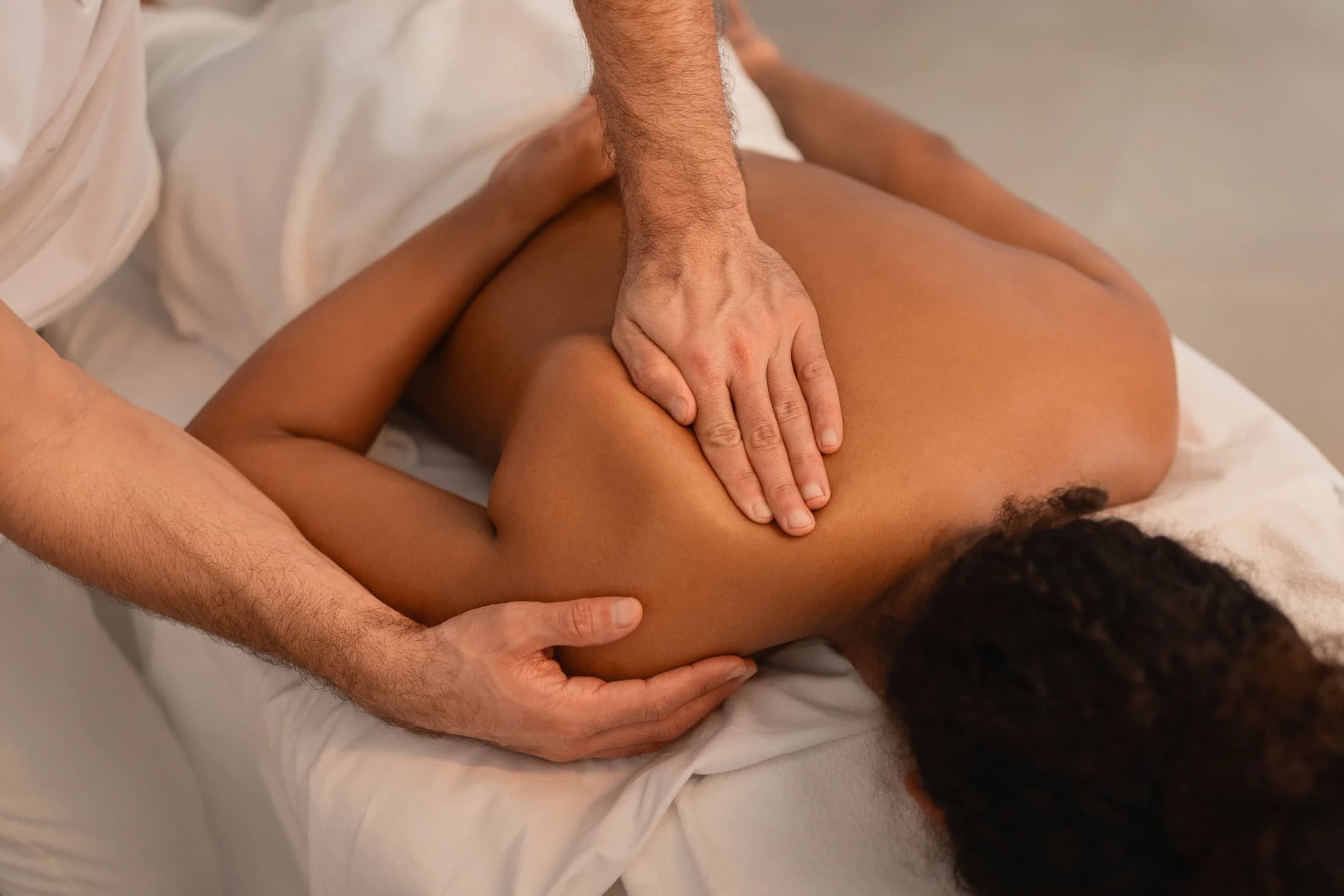 Therapeutic massage focused on the client's shoulder and upper back
