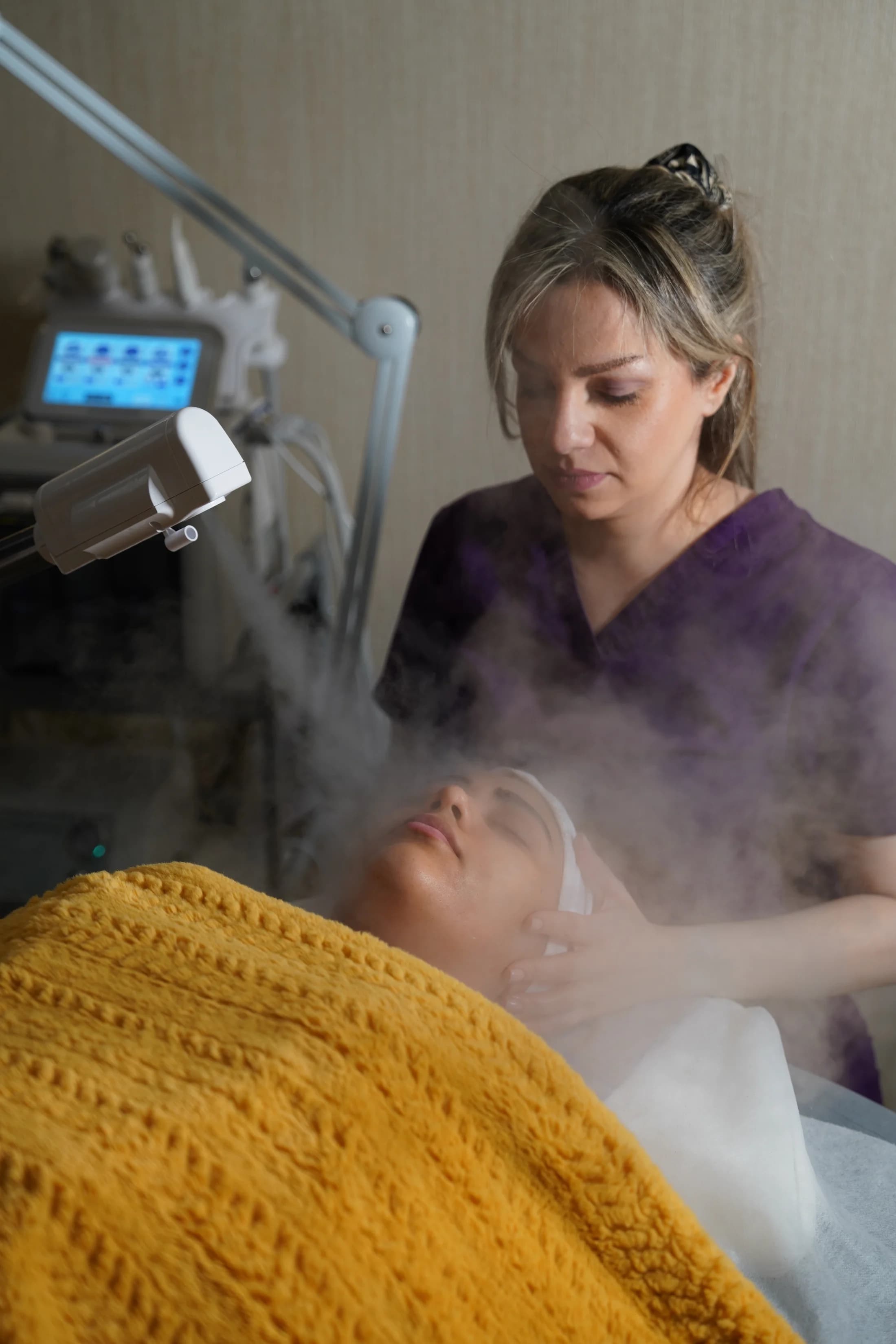 Warm steam hydrotherapy treatment applied to the client's face